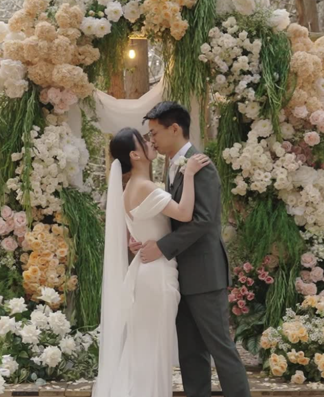 Ceremony kiss beneath a floral arch